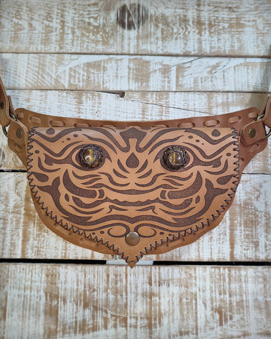 Bohonito belt bag with an interchangeable flap showing a unique engraved kirtmukha pattern and natural tiger eye stone.