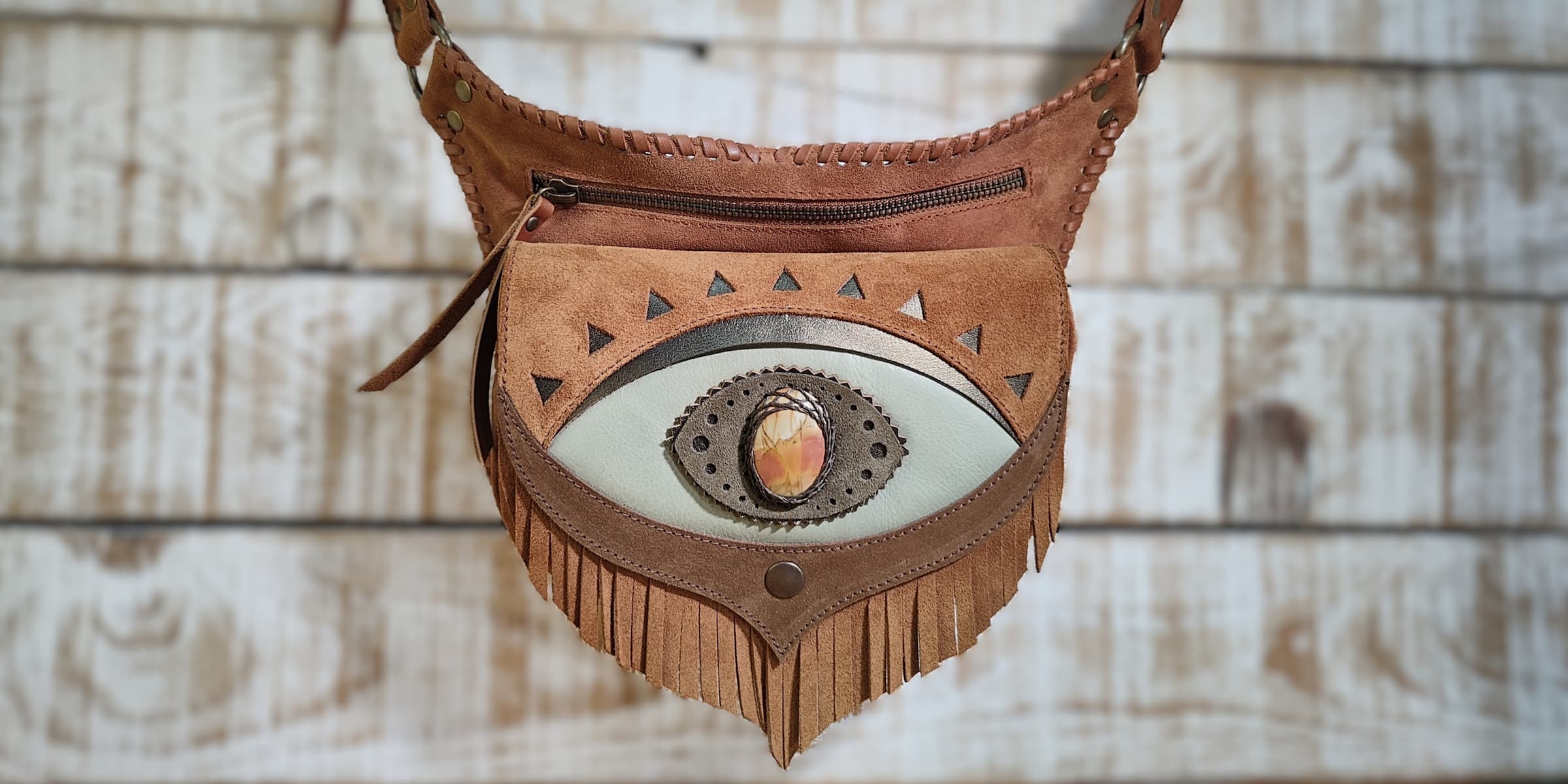 Bohonito Omara brown leather belt bag with mystical third eye design, polychrome jasper stone, and handmade fringe flap, artisanal festival style.