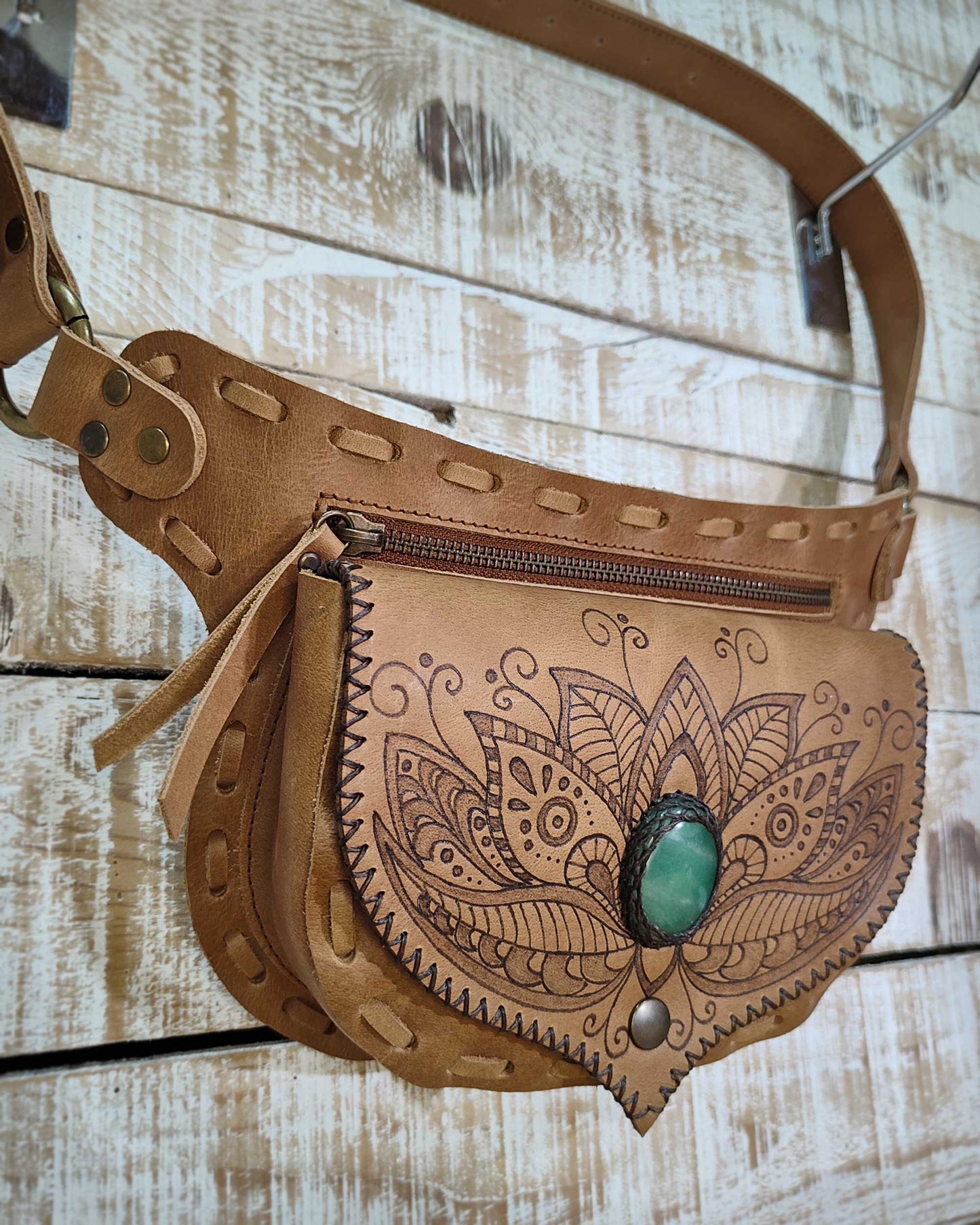 Detail shot of the hand-burned henna floral pyrography on the natural leather flap, centered with a polished natural green aventurine stone.