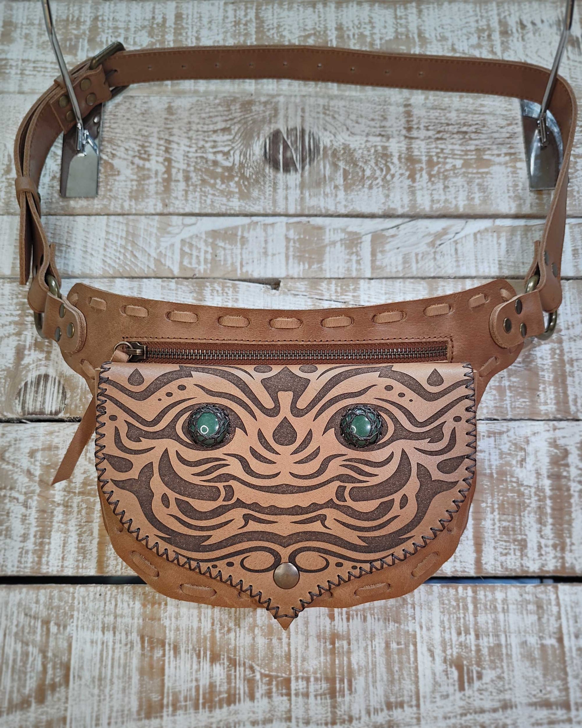 Detailed view of the interchangeable system on a Bohonito tan leather belt bag with green aventurines and a Kirtmukha engraved design.