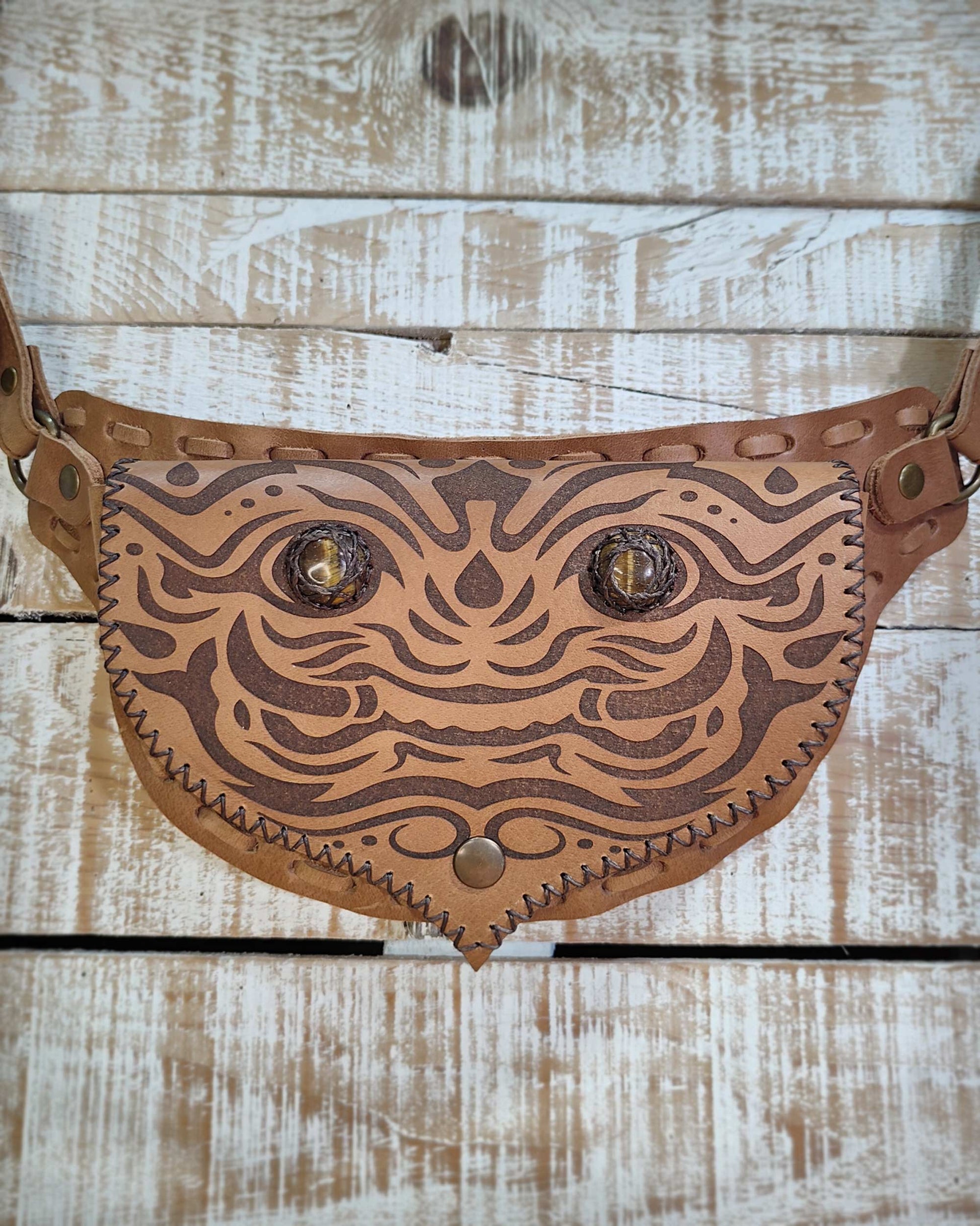 Bohonito belt bag with an interchangeable flap showing a unique engraved kirtmukha pattern and natural tiger eye stone.