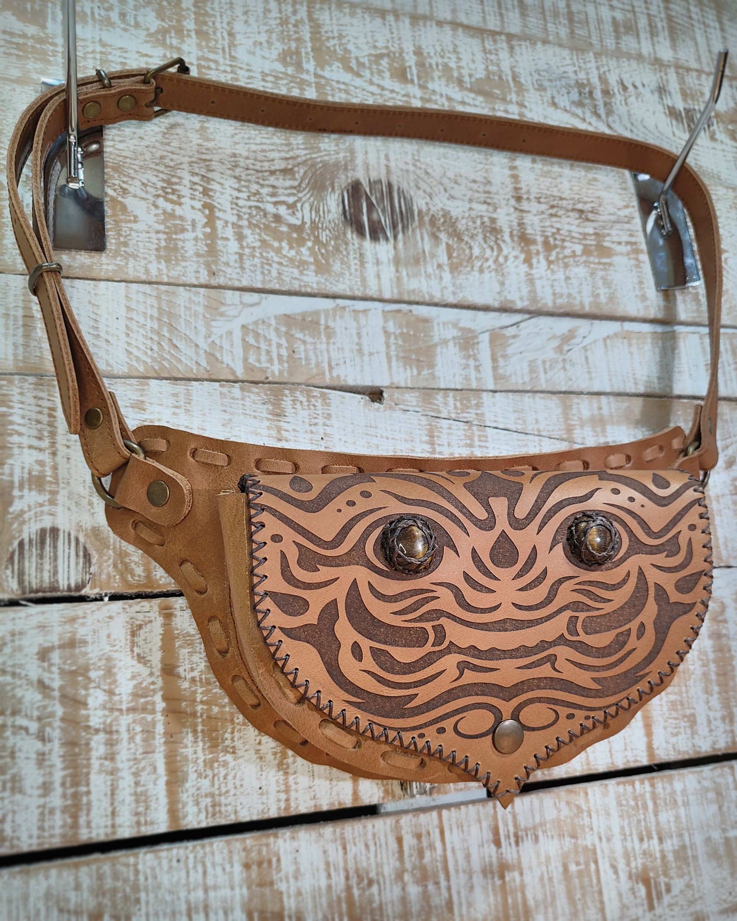 Detailed view of the interchangeable flap on this Bohonito leather belt bag with a kirtmukha engraving and tiger eye.