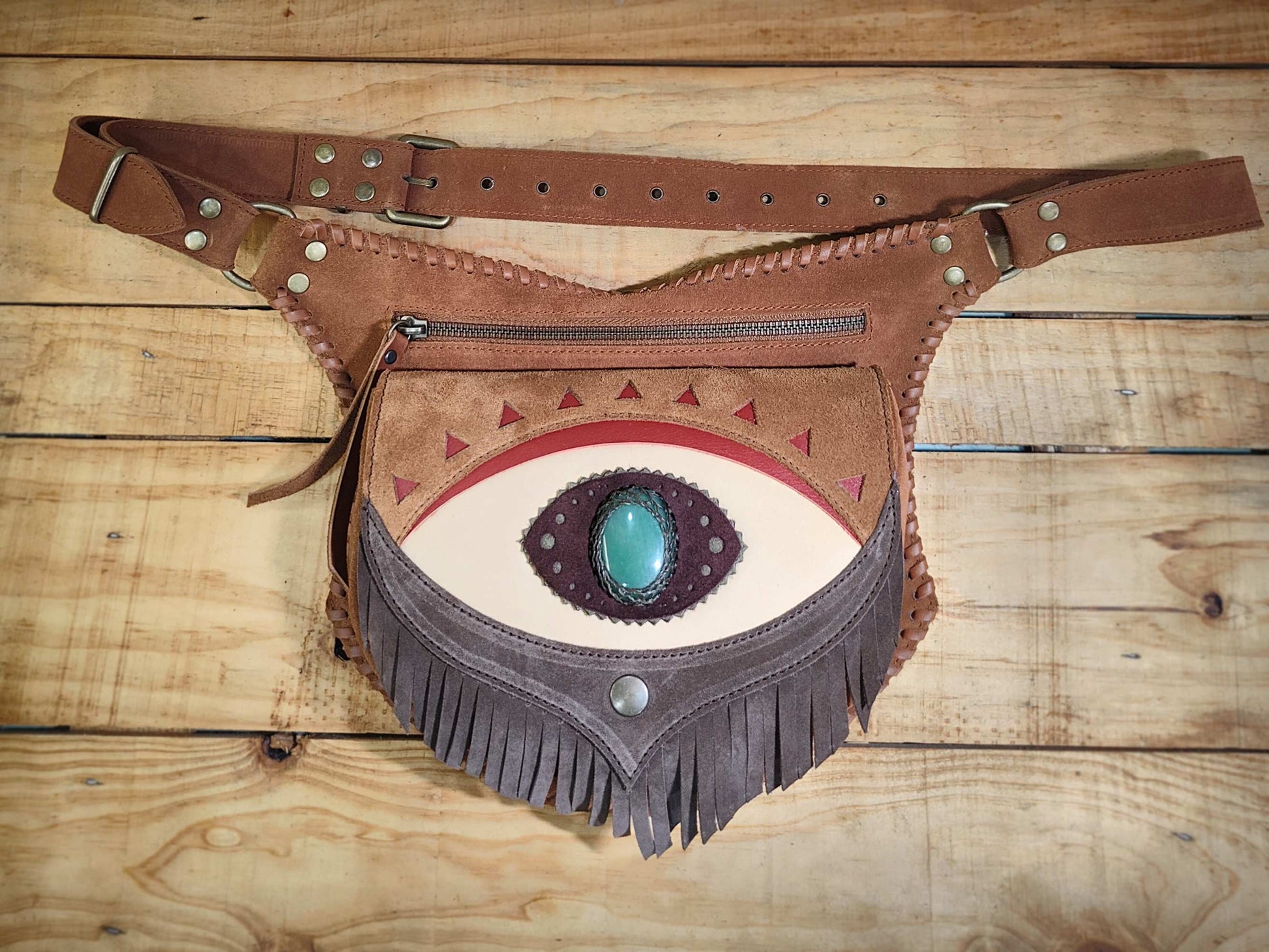 Bohonito Omara brown leather belt bag with a cream fringe flap featuring an Ajna Chakra design, aventurine stone inlay, and hand-laced edges.