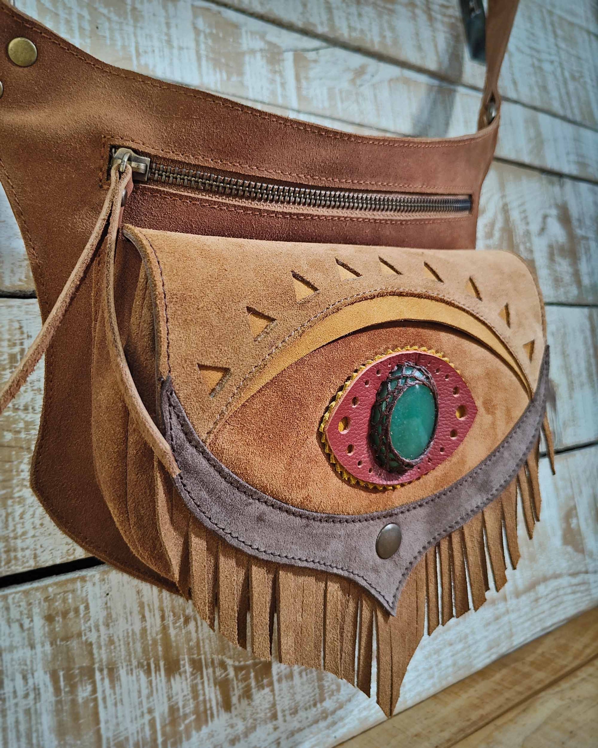 Boho leather festival belt bag with honey-colored fringe and Ajna eye design featuring a green aventurine.