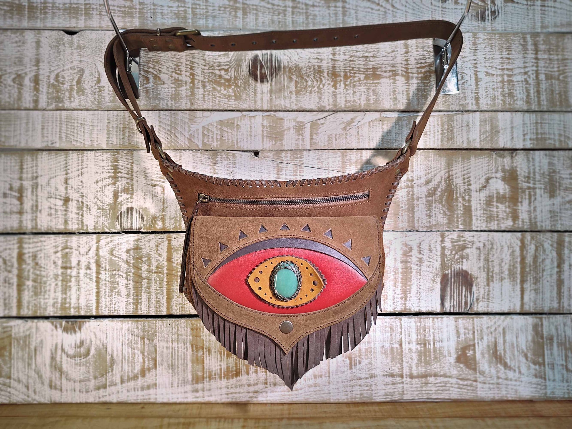 Bohonito Omara brown leather belt bag with a red fringed flap, Ajna Chakra design, aventurine stone, and hand-laced edges.