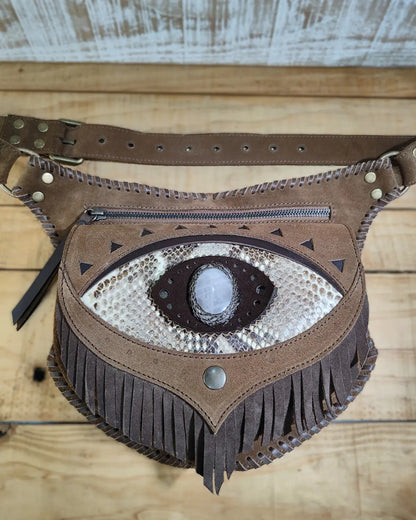 Artisanal belt bag by Bohonito featuring a red 'third eye' fringe flap, natural aventurine stone, and hand-laced leather detailing.